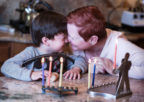 corta pelo rojo cabeza abuela y su nieto joven frotan narices frente a las velas de janucá disfrutando de las vacaciones - enzo fotografías e imágenes de stock