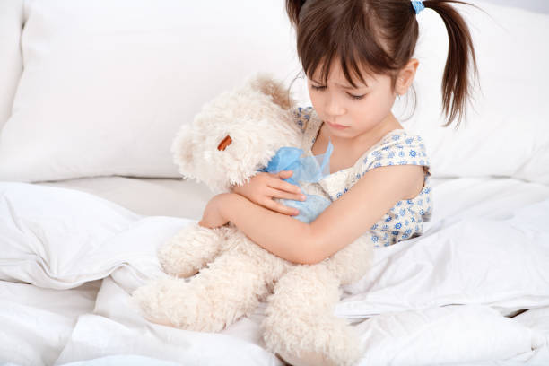 istock Sad girl hugging teddybear on bed 883578078