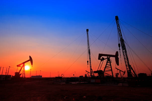 tempo do sol da bomba de óleo, equipamentos de indústria de petróleo - oil pumping unit at sunset time - fotografias e filmes do acervo