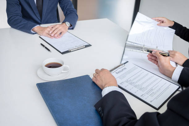 istock Interviewer or Board reading a resume during a job interview, Employer interviewing a young male job seeker for recruitment talking in modern office, employment and recruitment concept 883630420