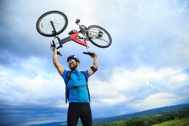 istock Cheerful biker lifting up his bike 883644288