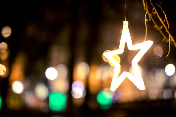 Christmas Neon Star on Tree in Centre of Cracov. Traffic lights in background. Night. Long exposure. Cracow in Poland.