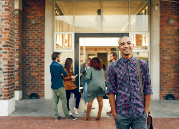 Some of the happiest days are spent at college Portrait of a happy young man standing outdoors on campus day 1 stock pictures, royalty-free photos & images