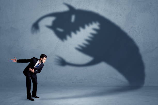 istock Business man afraid of his own shadow monster concept 883676232