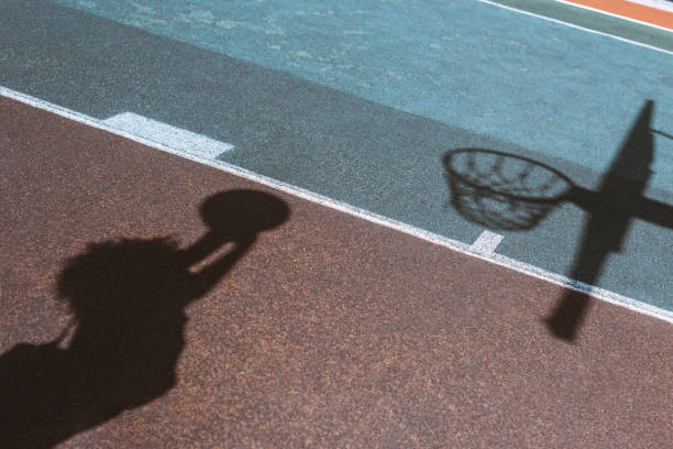 istock Shadow of woman throwing ball 883676558