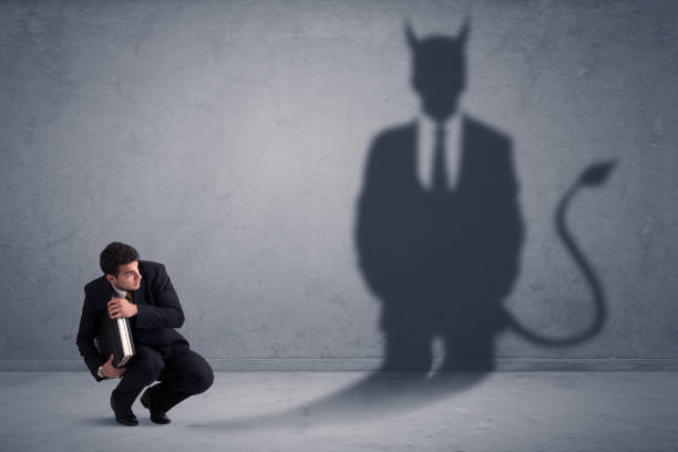 istock Business man looking at his own devil demon shadow concept 883676692