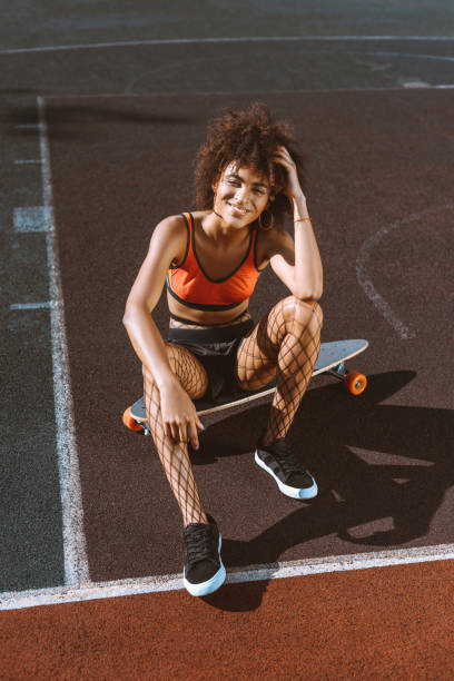 donna afro-americana a longboard - skateboard court foto e immagini stock