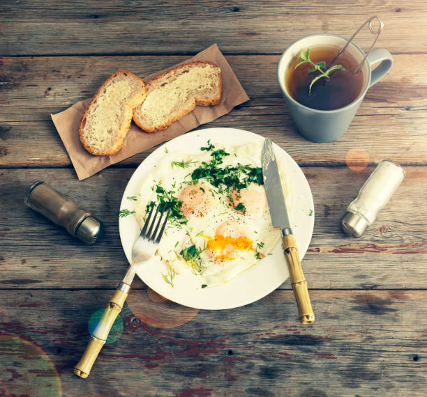 Fried eggs with greens on a white plate