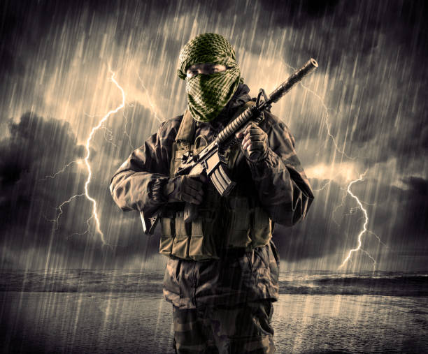 istock Dangerous armed terrorist with mask and gun in a thunderstorm with lightning 883687698