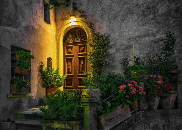 istock Door in an old house decorated with flower at night 883688430