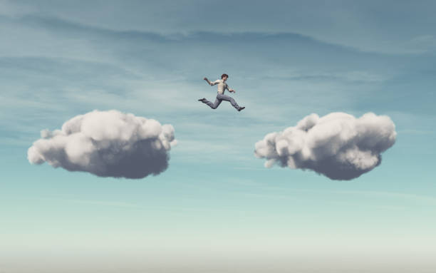 istock Businessman jumps on a cloud on another cloud. 883695178