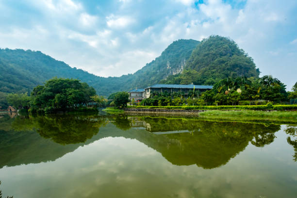 In a remote Mountain village in Zhejiang, China, an ancient stone bridge crosses the river.  This bridge holds a narrow path, only allowing a single file line when travelling by foot.  The remarkable rock formations, foggy atmosphere, clean reflections, and Wenzhou-style bridge makes this scene even more classic to me than traditional black and white Chinese paintings.  This composition truly brings ancient Chinese paintings to life.  This kind of bridge that lets the water pass through the stones is called \