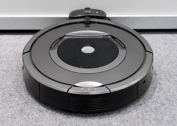 istock Robotic vacuum cleaner recharging charging on the base. 883702938