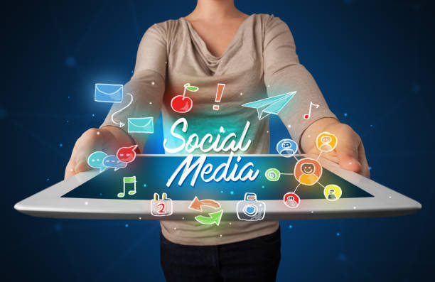 istock Woman holding tablet with social media graphics 883703178