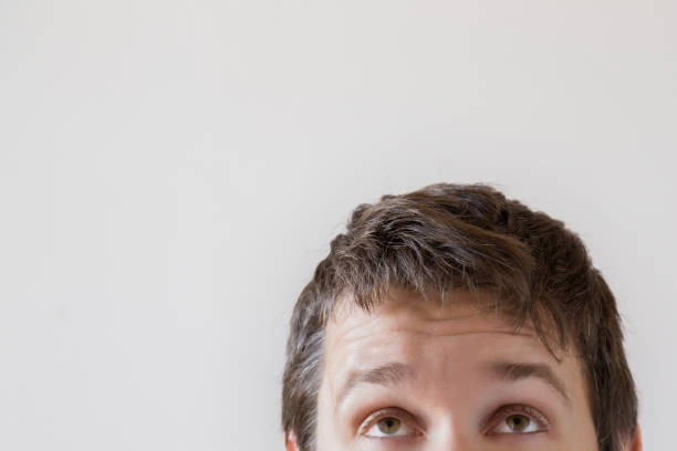 istock Man's eyes looking up on the gray background. Empty place for a text or object. 883718784