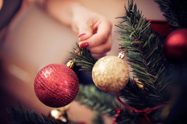 istock Close up of woman decorating Christmas tree 883720440