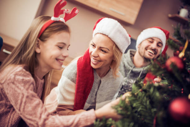 istock Mother,father and daughter decorating christmas tree. 883722722