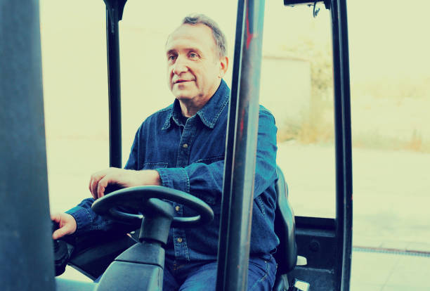 istock Elderly man of winery goes on loader 883726912