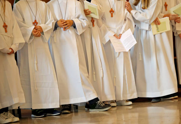 children with white tunic during the religious rite of the First Eucharistic communion in the chruch