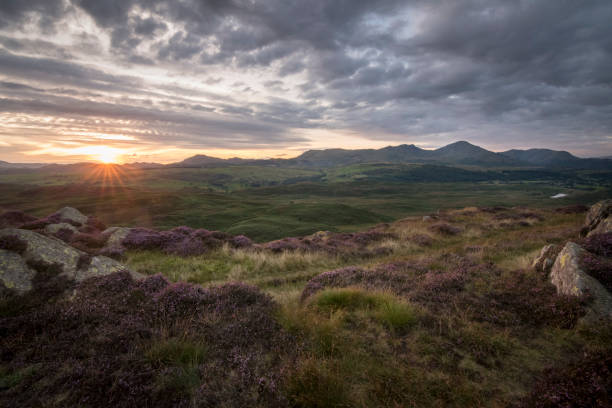 istock Star shape sun with beams warm the lake district landscape with mountain background 883739902