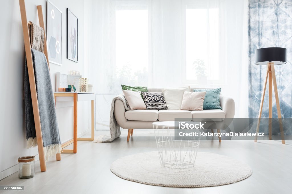 Ladder in bright living room White round carpet in bright living room with lamp and ladder near sofa with pillows Living Room Stock Photo