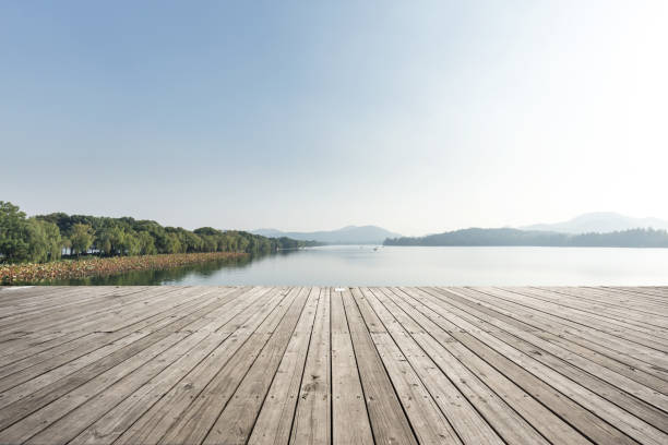 istock empty wooden floor with beautiful lake in blue sky 883744370
