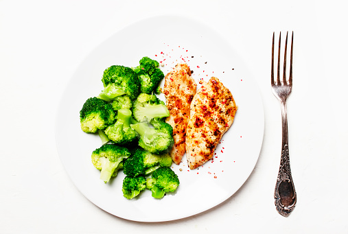 Grilled chicken and green broccoli, healthy lunch, white background, top view