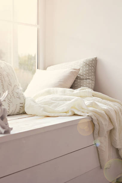 istock cushions and a knitted plaid on the windowsill. 883760352