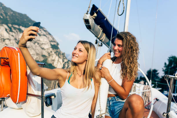 istock Women together go up on sailboat 883769972