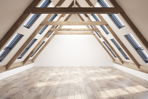 Empy attic room interior with white walls, a wooden floor, a pitched roof with many windows in it. 3d rendering copy space