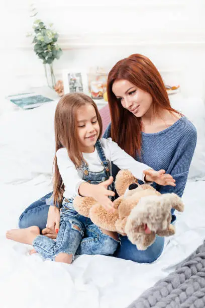 Photo of A little cute girl enjoying, playing and creating with toy with mother