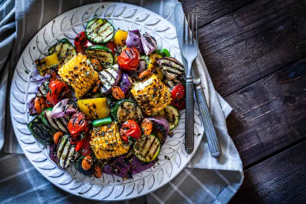 Photo of Grilled vegetables plate shot from above on rustic wooden table