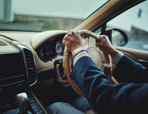 Cropped shot of a businessman driving a stylish car