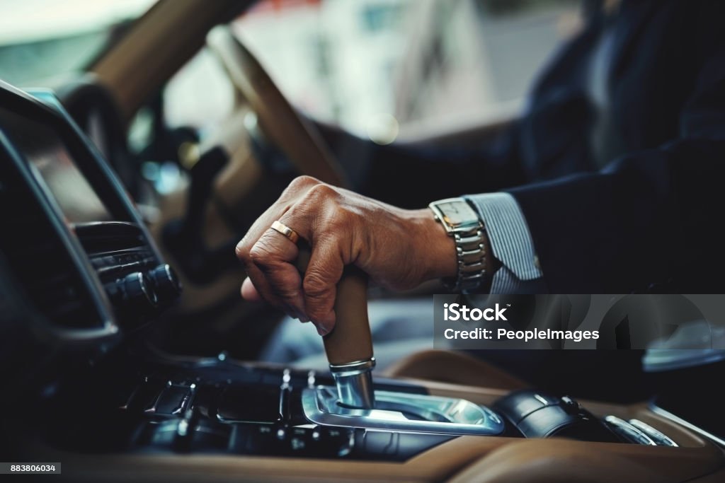 All geared and good to go Cropped shot of a businessman changing the gears of a car Luxury Stock Photo