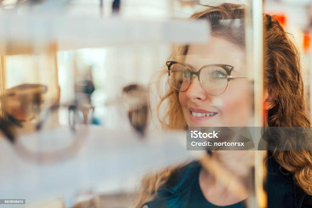 Happy girl deciding to buy new glasses. Eyeglasses Stock Photo