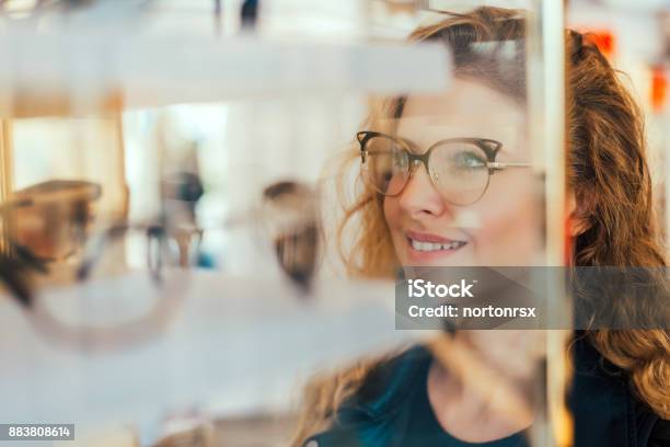 Happy Girl Deciding To Buy New Glasses Stock Photo - Download Image Now - Eyeglasses, Optometrist, Store