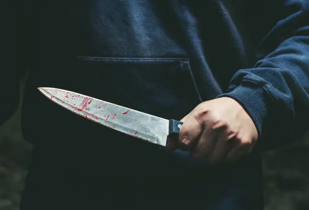 Photo of A man with a bloody knife in his hand