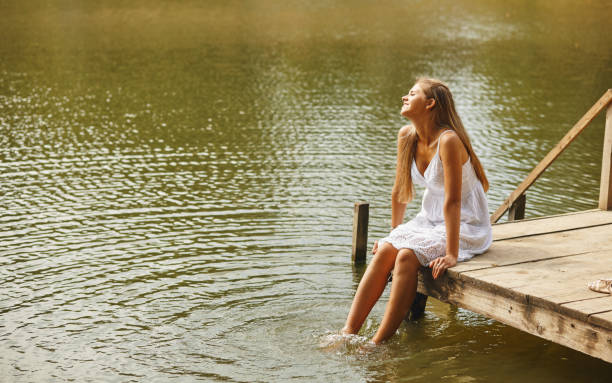 istock A pretty girl relaxes at the pier 883845220