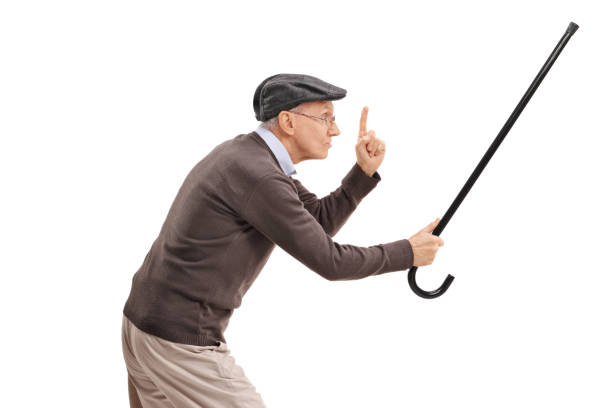 istock Angry senior holding his cane as a sword and gesturing with his finger 883885296