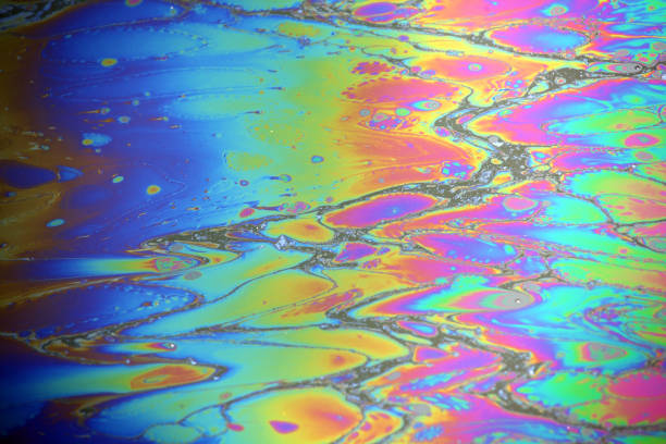 abstracto colorido arco iris mancha de aceite en el fondo del agua - pollution oil oil slick water pollution fotografías e imágenes de stock