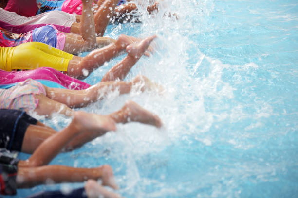 istock group of children at swimming pool class learning to swim 883896608