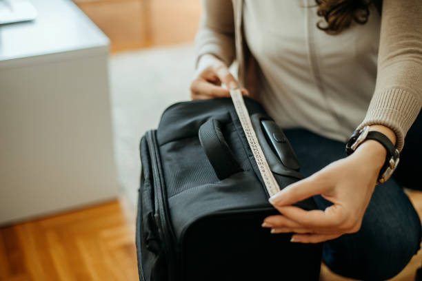 istock Woman measuring luggage size. 883897636