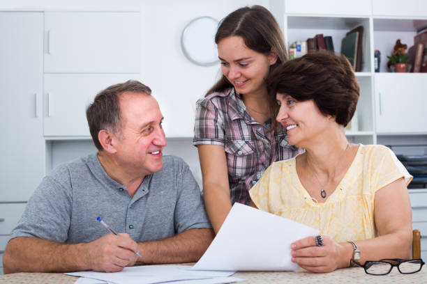 istock Positive woman helping her parents to do paperwork 883900904