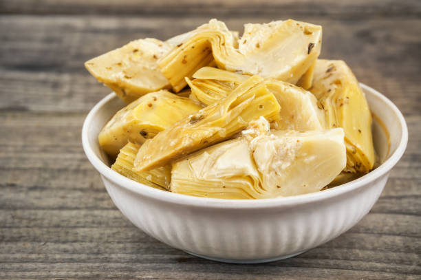 marinated artichokes in bowl marinated delicious artichokes in bowl on wooden background vinegar stock pictures, royalty-free photos & images