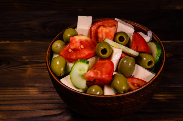 istock Greek salad in a bowl on wooden table 883919848