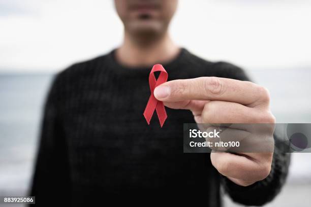 Man With Red Ribbon For The Fight Against Aids Stock Photo - Download Image Now - HIV, AIDS, AIDS Awareness Ribbon