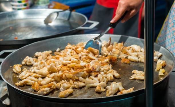 istock Cooking a lot of  fried squid in a large pan 883958202