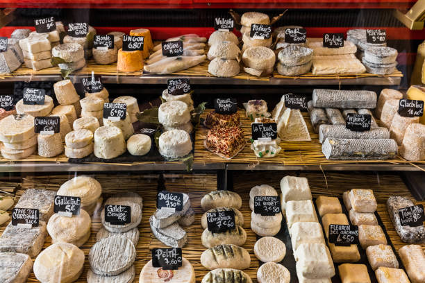 different cheeses on the counter of a small store at the aligre market. paris, france - cultura francesa imagens e fotografias de stock