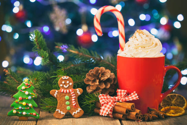 istock Christmas cappuccino and gingerbread cookies infront Christmas tree on Rustic Wooden Table 883968060