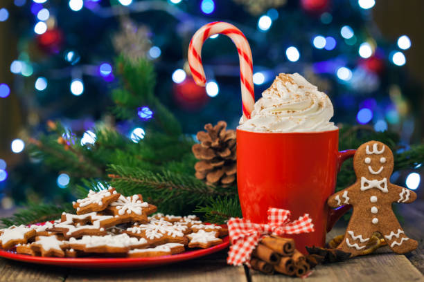 istock Christmas cappuccino and gingerbread cookies infront Christmas tree on Rustic Wooden Table 883969266